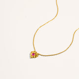 Gold vermeil kids heart pendant necklace shown at an angle, featuring vivid pink ruby corundum stone, luxury fine jewelry gift for girls.