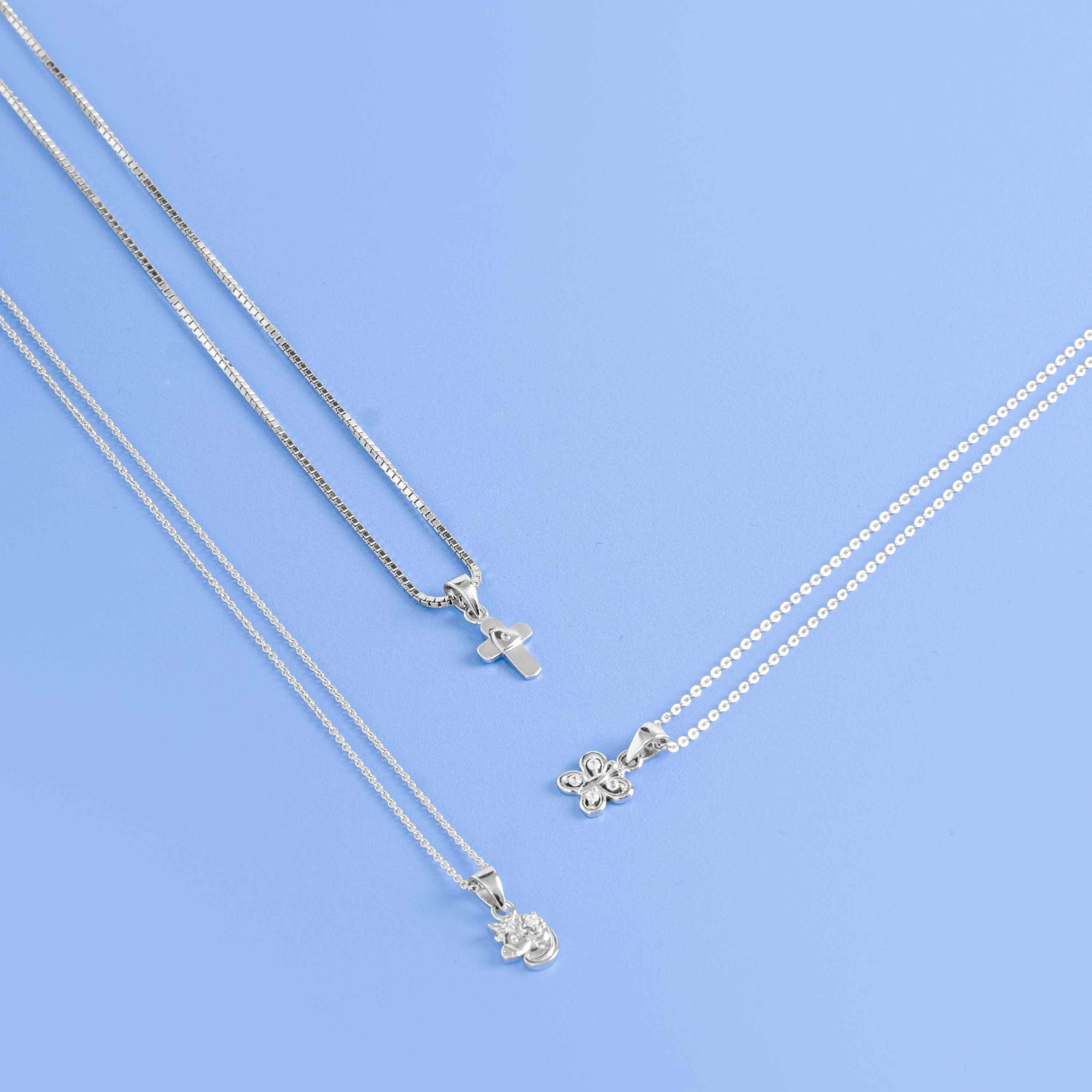Three sterling silver necklace flat lay on blue surface