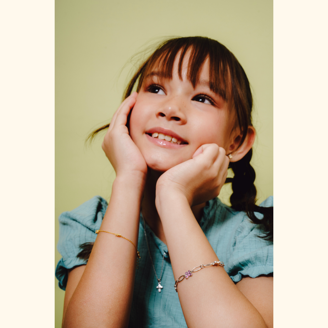 A young girl wearing Blue Francis fine jewelry bracelets, including the gold vermeil and sterling silver styles, featured in Playtime New York's Contemporary Classical brand selection.