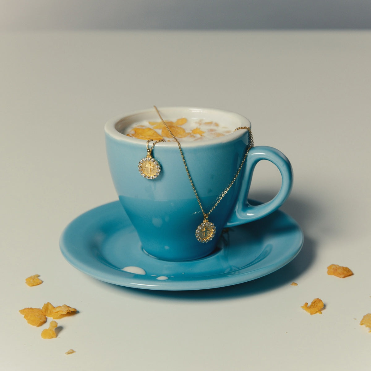 Still Life Photography for Twinkle Necklace on blue cup full of milk.