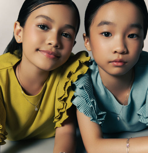 Two children in pastel tops wearing silver jewelry — Brooklyn Unicorn Necklace, Blue Francis