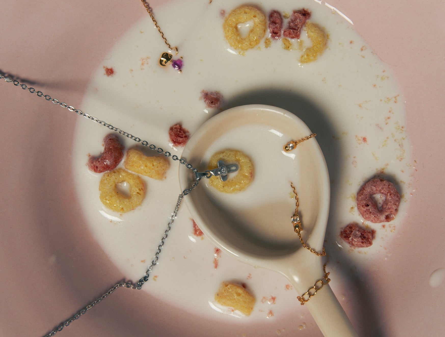 Jewelry arranged in a pink bowl with cereal and milk — SS25 Collection, Blue Francis.