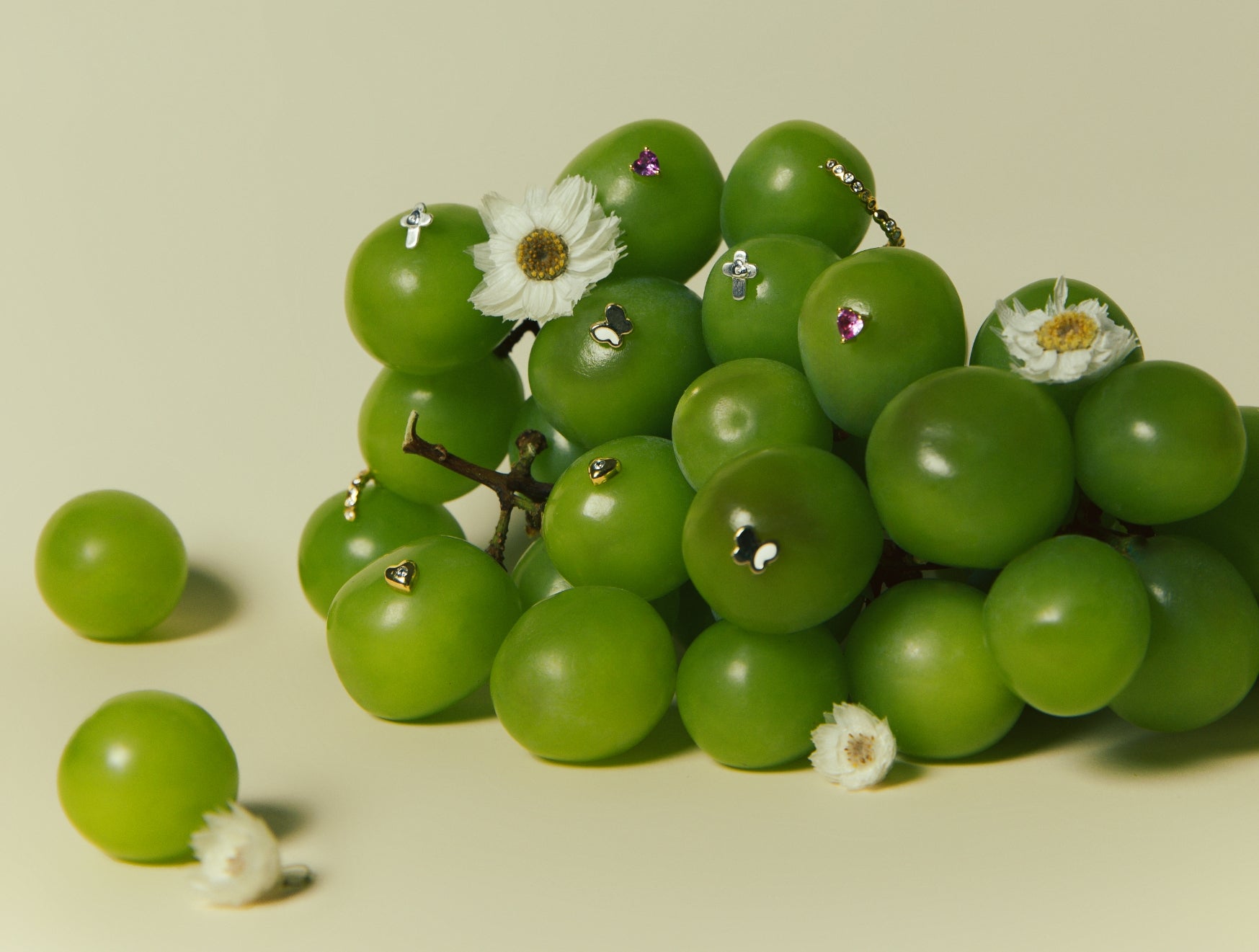 Green grapes decorated with small jewelry pieces and white flowers — Earrings Collection, Blue Francis.