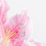 Blue Francis Liam Heart Clasp Necklace and Liam Circle Clasp Necklace in sterling silver on a pink lily
