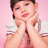 Girl wearing the Melodie Chain Pearl, a freshwater pearl bracelet for girls in gold-plated sterling silver