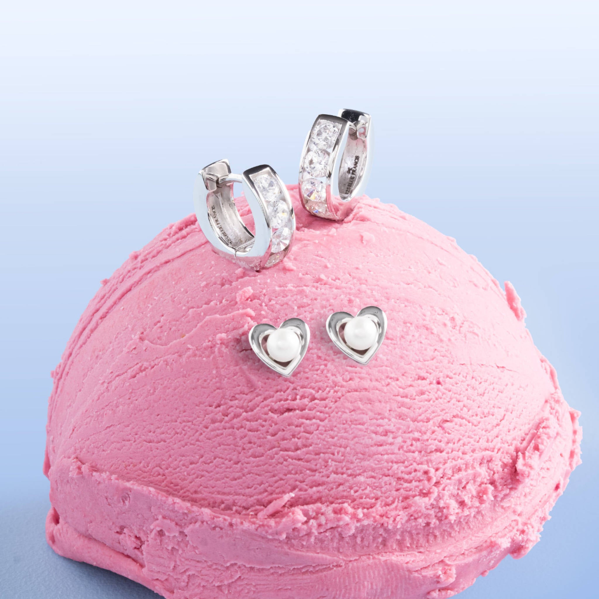 Blue Francis Gramercy Hoops, sterling silver CZ huggie earrings for girls, styled with Brooklyn Heart Pearl studs on a pink ice cream scoop