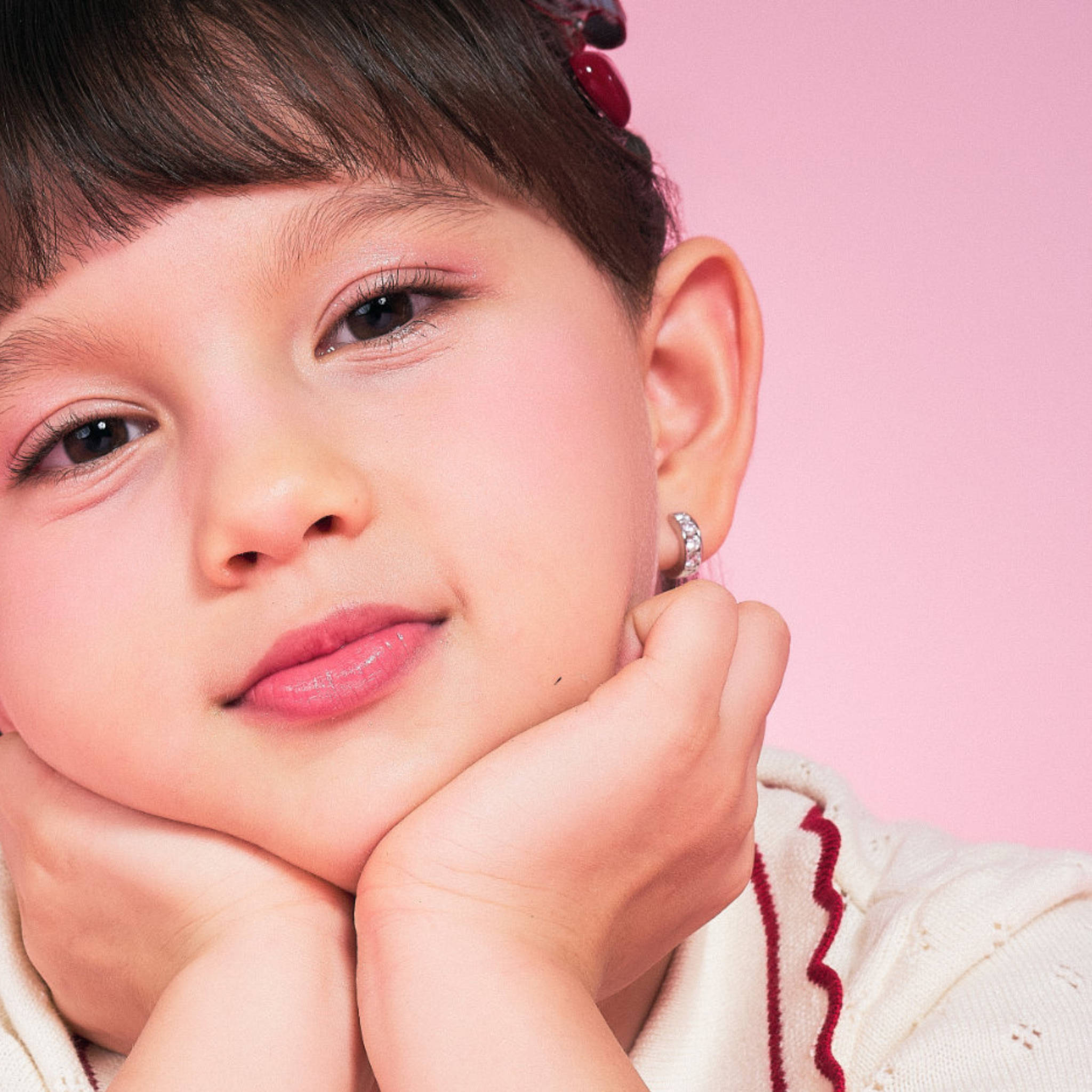 Girl wearing Blue Francis Gramercy Hoops, small sterling silver CZ huggie earrings sized for kids