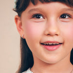Girl wearing Blue Francis Gramercy Hoops Thin, delicate silver huggie earrings with cubic zirconia