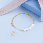 Blue Francis Melodie gold pearl bracelet with freshwater pearls and figaro chain, shown with butterfly stud earrings and signature ribbon