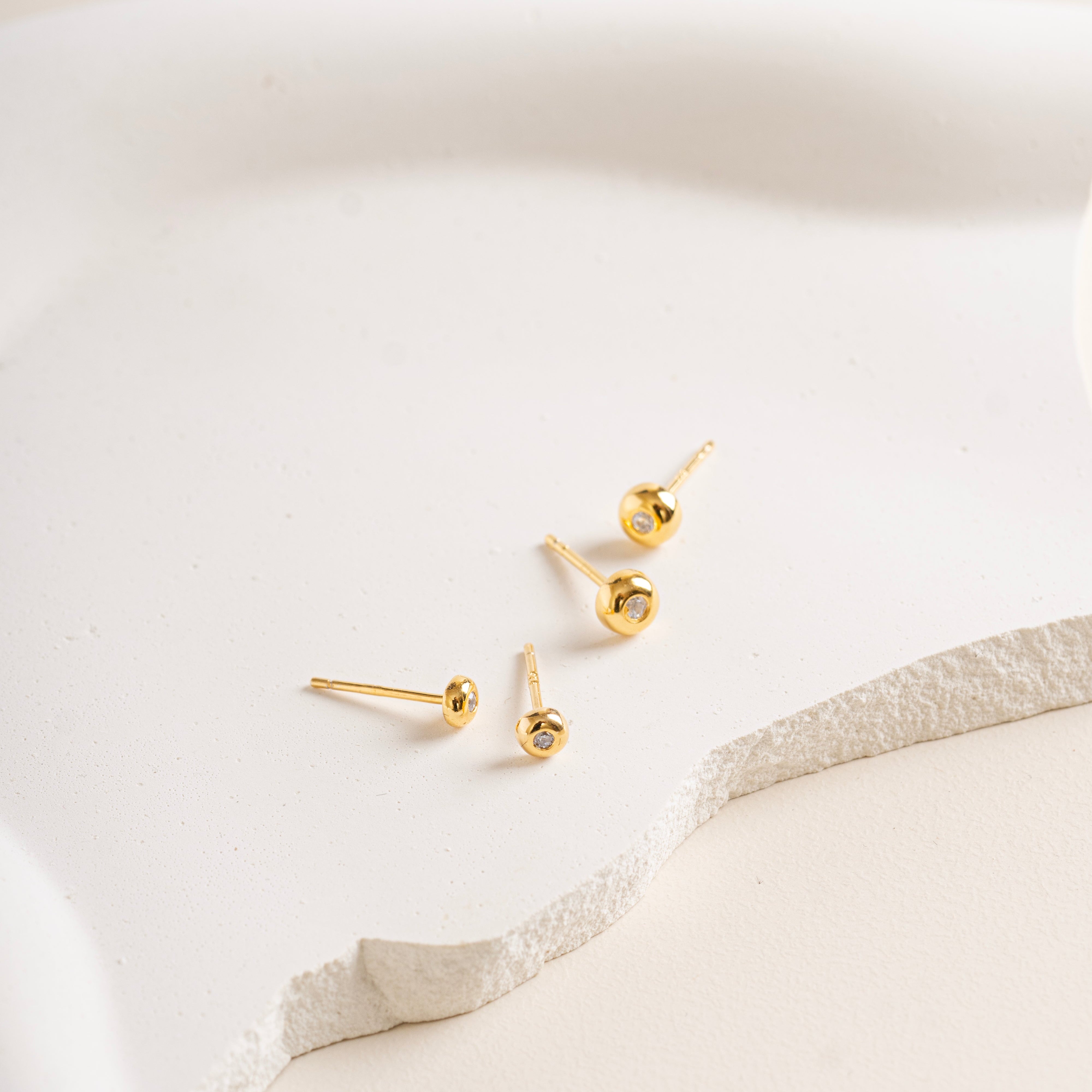 Gold vermeil Twinkle Circle Studs on a white soft cream background in big and small size - Blue Francis