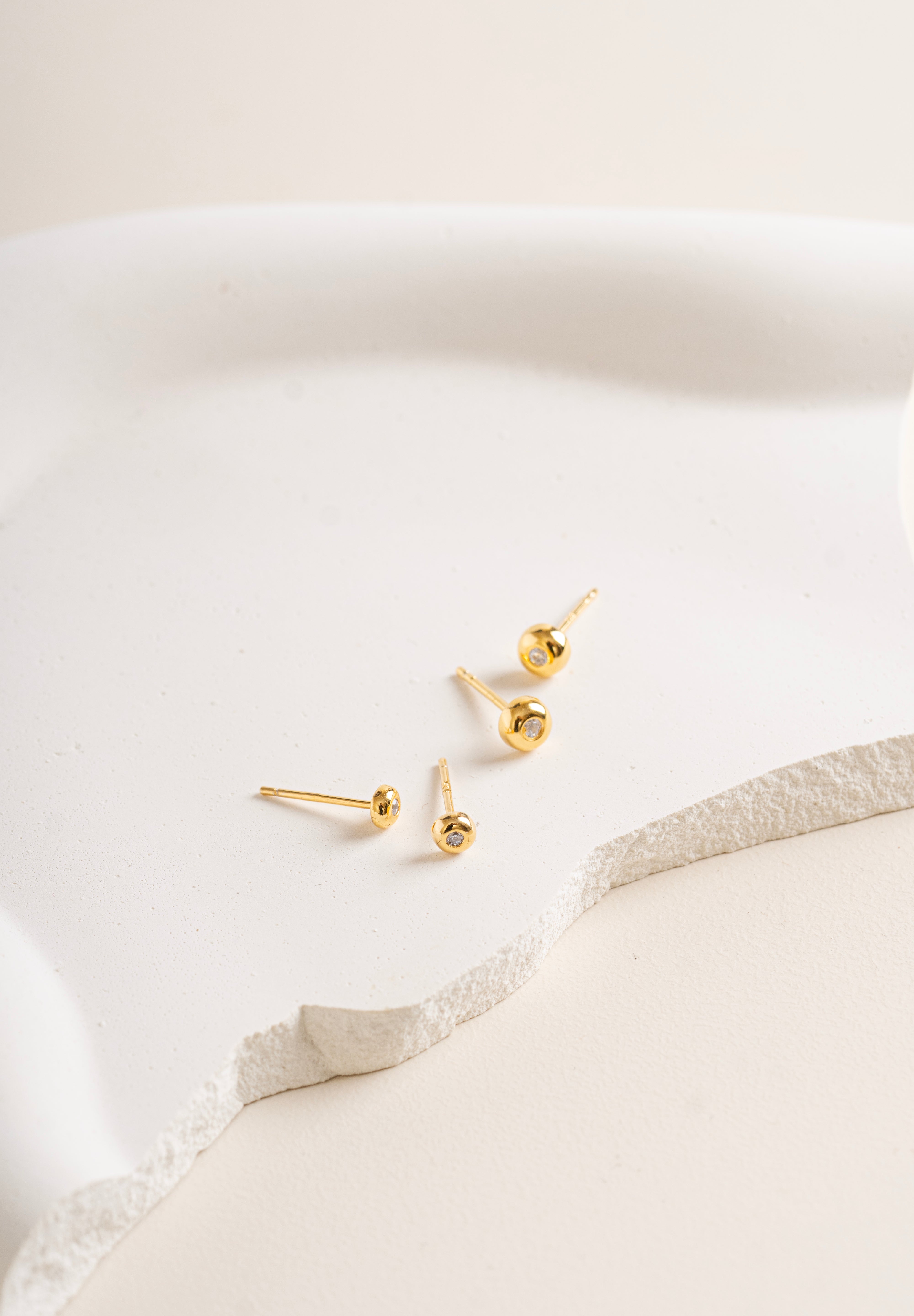 Gold vermeil Twinkle Circle Studs on a white soft cream background in big and small size - Blue Francis