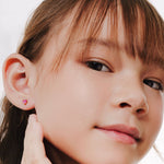 Blue Francis Kids Earring in Vermeil 18K Gold called Ruby Liberty Studs. Blue Francis model having a close up picture while wearing Ruby Liberty Studs. 
