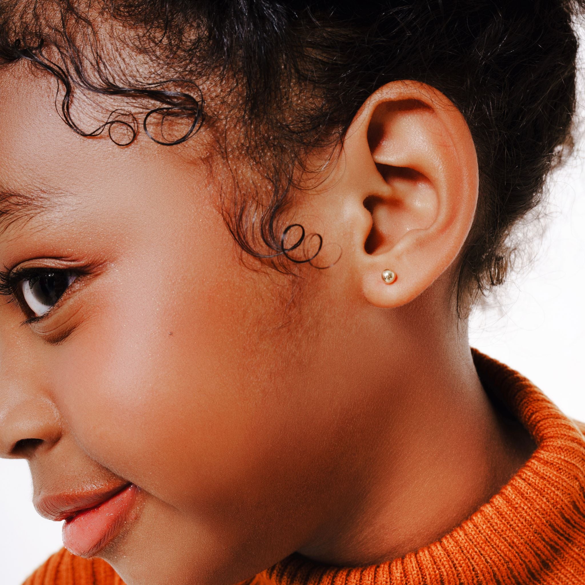 Blue Francis - Kids Stud Earrings - Gold 14K - Soho Ball Studs. A Close-up picture of a child wear a Golden ball studs earring.