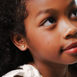 Blue Francis - Kids Stud Earrings - Gold Solid 14K - Soho Heart Studs. Close-up picture of a model with Solid Gold earrings for kids. 