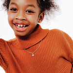 Child wearing an orange sweater with a white background using Brooklyn Butterfly Pendant on Box Chains