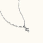 Brooklyn Cross Necklace in sterling silver and cubic zirconia with heart center, photographed from side angle on neutral background to show shape detail.