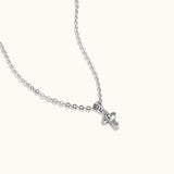 Brooklyn Cross Necklace in sterling silver and cubic zirconia with heart center, photographed from side angle on neutral background to show shape detail.