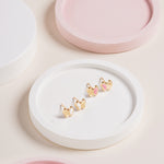 Blue Francis Pink Hudson Butterfly Studs crafted in 14K gold with pink enamel wings, displayed on a white round tray with pastel pink styling.