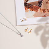 Soho Ball Studs in polished 14K gold shown near a silver necklace on a neutral background with a flat lay composition with magazine.