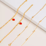 Vermeil chain bracelet with sparkling Cubic Zirconia stones, pictured together with Red Central Heart Bracelet on cream background.
