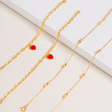 Vermeil chain bracelet with sparkling Cubic Zirconia stones, pictured together with Red Central Heart Bracelet on cream background.