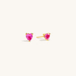 Ruby Liberty Stud Earrings in vermeil with ruby corundum stones shown from a side angle on neutral background to display prong setting detail clearly.