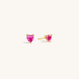 Ruby Liberty Stud Earrings in vermeil with ruby corundum stones shown from a side angle on neutral background to display prong setting detail clearly.