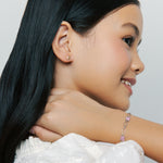Model wearing Brooklyn Butterfly Bracelet in sterling silver and pink enamel with Pink Hudson Butterfly Earrings, smiling on neutral background.